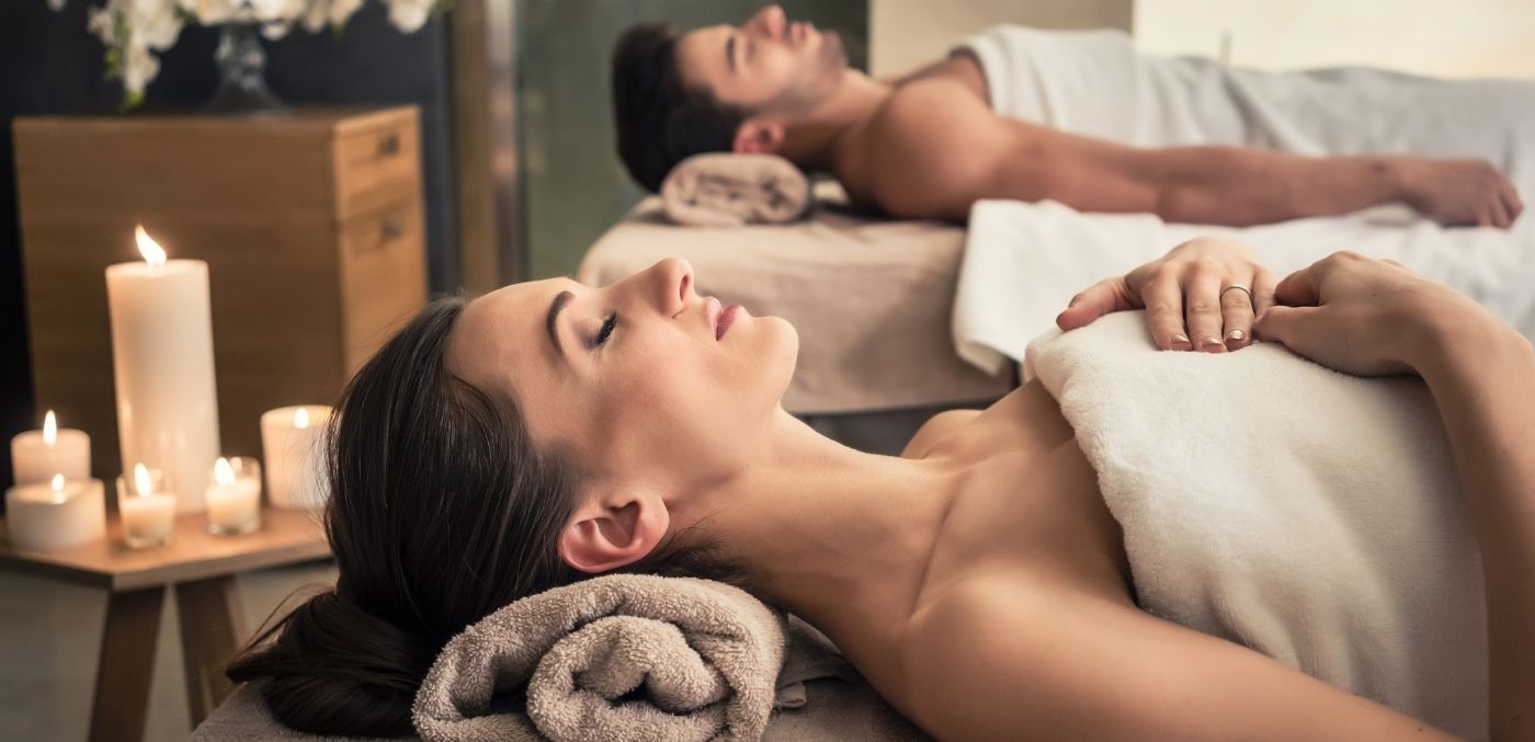 man and woman laying on massage tables