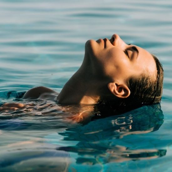 woman submerging head in a pool